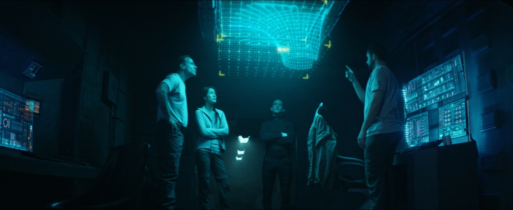 Captain McKay (David M. Edelstien), Moira, Cole and Andrew Jensen (Ben Kliewer) study a holographic display that offers clues as to their predicament.