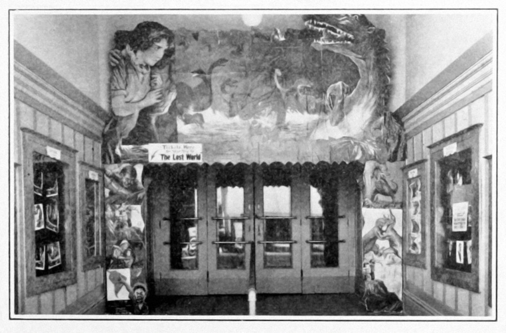 “Striking cut-out display for ‘The Lost World’ designed by Manager W.A. Crank and used at the Majestic Theatre, Chico, Calif. The cut-outs over the entrance and on lobby stands were made from stock paper. Baby spots, shown in upper corners of the photo, illuminated the display.” Original caption – Moving Picture News 20 Feb 1926